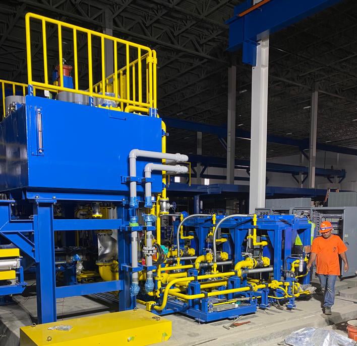 Photo of a contractor working on a project installation walking alongside machinery.